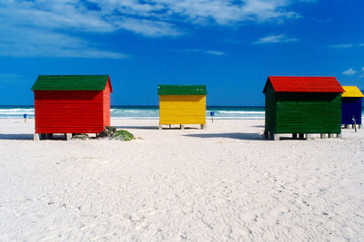 Huts on beach against sky