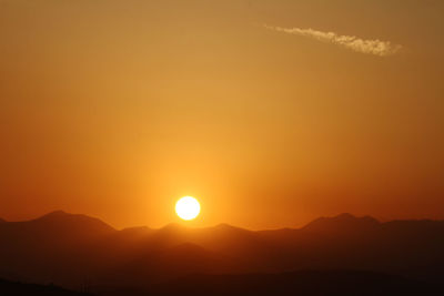 Scenic view of silhouette mountains against romantic sky at sunset