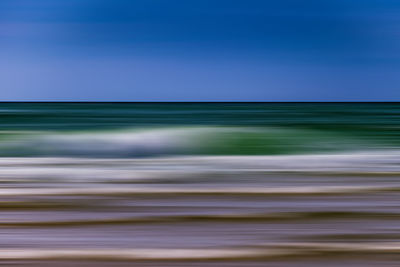 Blurred motion of sea against blue sky