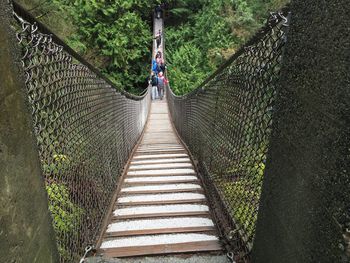 Rear view of person walking on footbridge