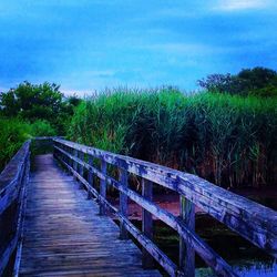 View of wooden footbridge against clear sky