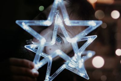 Close-up of hand holding illuminated lighting equipment