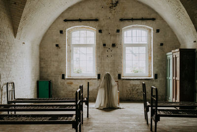 Little ghost standing in the abandoned house. autumn halloween