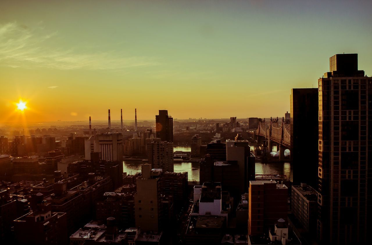 architecture, building exterior, sunset, built structure, city, cityscape, skyscraper, sun, tower, tall - high, crowded, orange color, sky, modern, development, office building, high angle view, city life, urban skyline, residential district