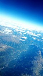 Aerial view of landscape against blue sky