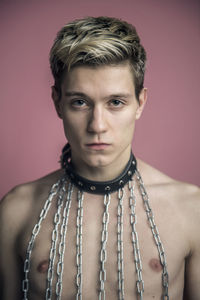 Portrait of young man standing against gray background