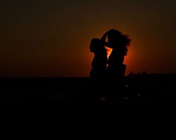 Side view of silhouette woman sitting at sunset