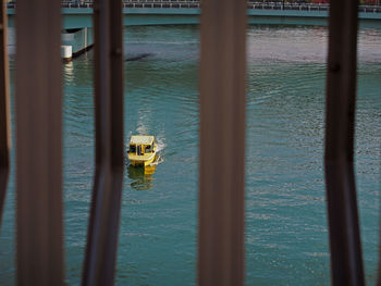 Far distance of a yellow taxi boat in the green turquoise color ocean. 