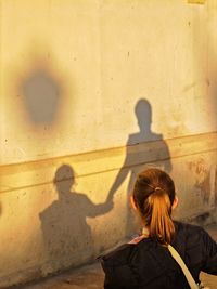 Low angle view of woman standing against wall