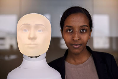 Portrait of young woman with robot voice assistant