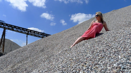 Low angle view of woman with umbrella against sky