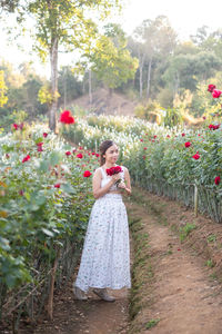 Rear view of woman standing amidst plants