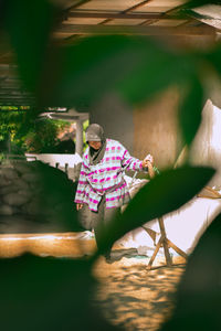 Young man sitting by plants