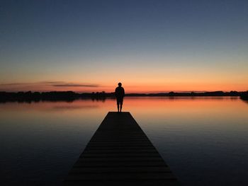 Silhouette of man standing on jetty