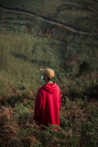 Rear view of man wearing mask looking at field