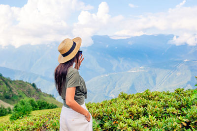 Man standing on mountain peak against sky