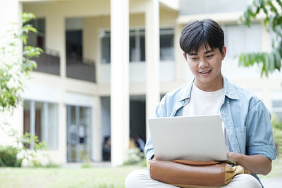 Smiling young man using mobile phone