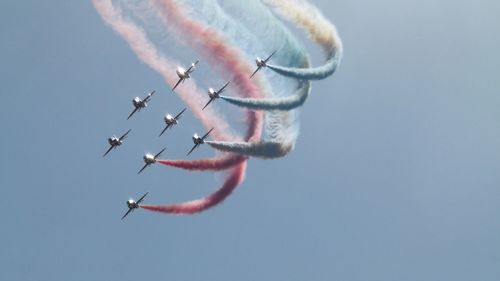 Low angle view of airshow against sky.  red arrows 