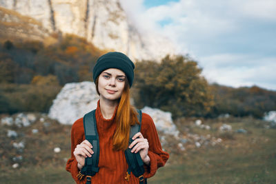 Portrait of young woman wearing hat standing outdoors