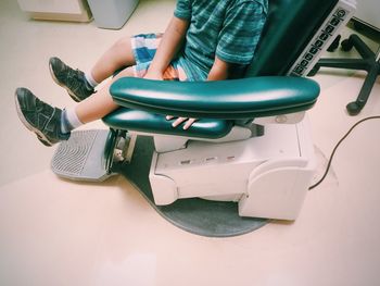 Low section of boy sitting on dentist chair