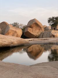 Reflection of rocks in lake against sky