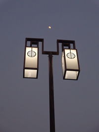 Low angle view of illuminated street light against sky