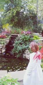 Rear view of girl standing against trees