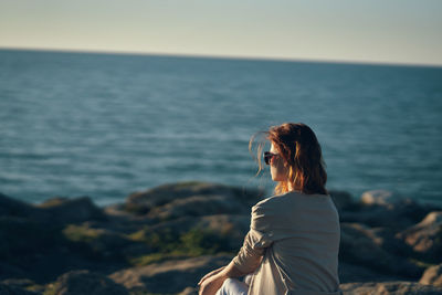 Woman looking at sea against sky