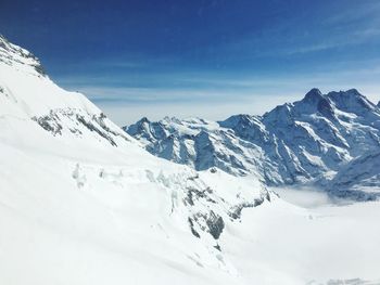 Scenic view of snow covered mountains against sky