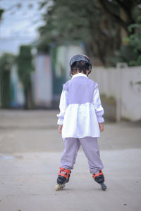 Portrait of young woman walking on footpath