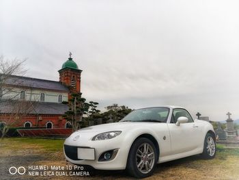 Vintage car on building against sky