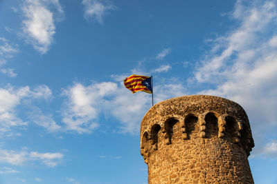 Low angle view of flag against blue sky