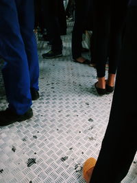 Low section of man standing on tiled floor