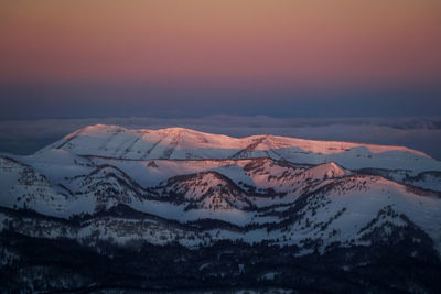 Scenic view of snowcapped mountains against sky during sunset