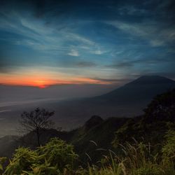 Scenic view of mountains against sky at sunset