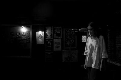 Young woman standing by microphone at recording studio