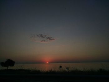 Scenic view of silhouette field against sky at sunset