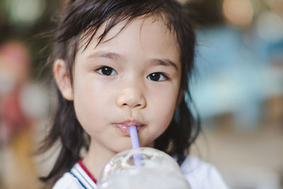 Close-up portrait of cute girl having drink