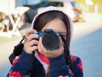 Close-up of girl photographing with camera