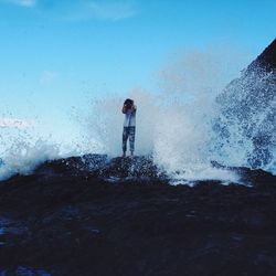 Woman standing on mountain against sky