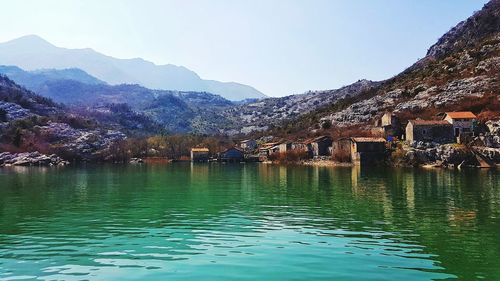 Scenic view of lake by mountains against sky