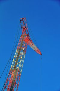 Low angle view of ferris wheel against blue sky