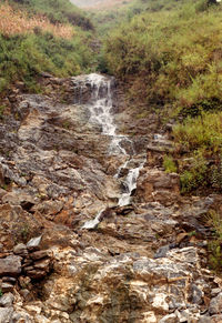 View of stream flowing through rocks