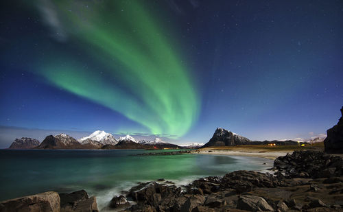 Scenic view of lake and mountains against sky at night