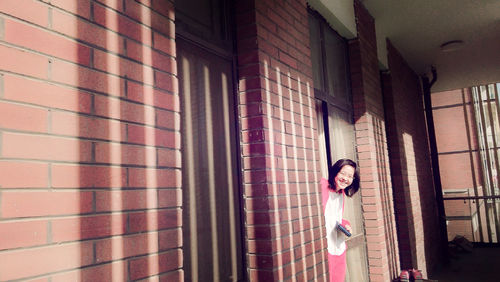 Silhouette of woman against brick wall