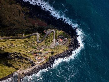 Directly above shot of rocky coastline by sea