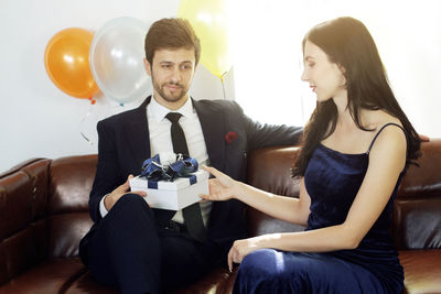 Young couple sitting on balloons