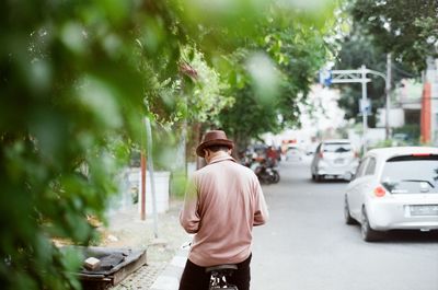 Rear view of man walking on street in city