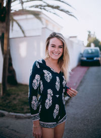 Portrait of smiling young woman standing outdoors