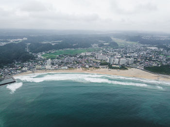 Aerial view of buildings and sea against sky